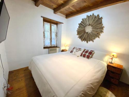 a bedroom with a white bed and a mirror on the wall at Rustic Chic de Luxe 47E in El Tarter