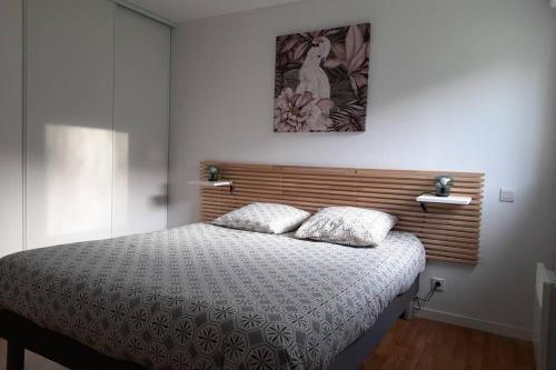 une chambre avec un lit et un tableau au mur dans l'établissement Appartement avec vue mer 3 étoiles, à Paimpol