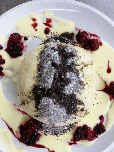 a white plate with a dessert with berries on it at Penzión Turista in Banská Štiavnica