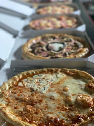 a row of pizzas in trays on a table at Penzión Turista in Banská Štiavnica