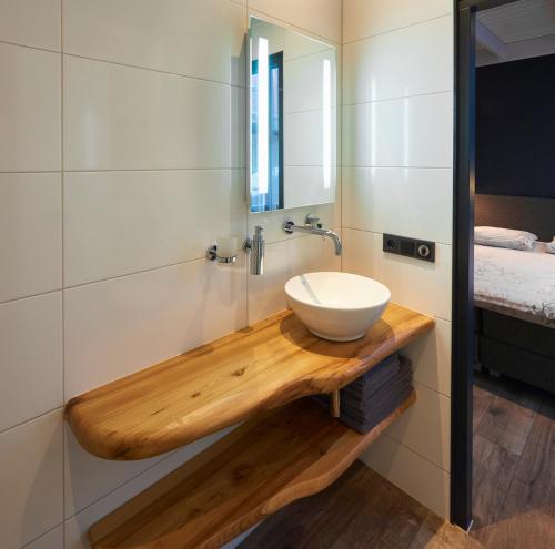 een badkamer met een wastafel op een houten aanrecht bij D'n Wasschappelsen Engel Windkracht 9 en Windkracht 10 in Westkapelle