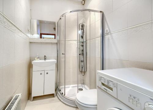 La salle de bains est pourvue d'une douche, de toilettes et d'un lavabo. dans l'établissement Mieszkanie Albatros - ACCO RENT, à Sopot