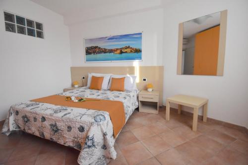 a hotel room with a bed and a night stand at Residence Il Cardellino in San Vincenzo