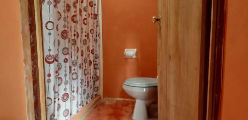 a bathroom with a toilet and a shower curtain at Centro Ecoturistico Ya´ajche in Lacanjá