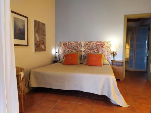 een slaapkamer met een bed met oranje kussens bij Gomera Garden. Vista Mar Altozano in Hermigua