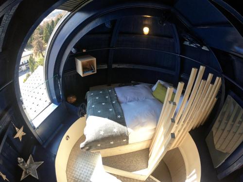 anorthole of a room with a bed and a chair at Sternwarte by Randolins in St. Moritz