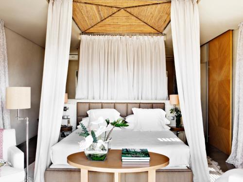 a bedroom with a canopy bed with a table at The Villas at Bahia del Duque in Adeje