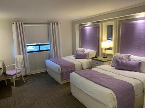 a hotel room with two beds and a window at Rose Hotel in Monterrey