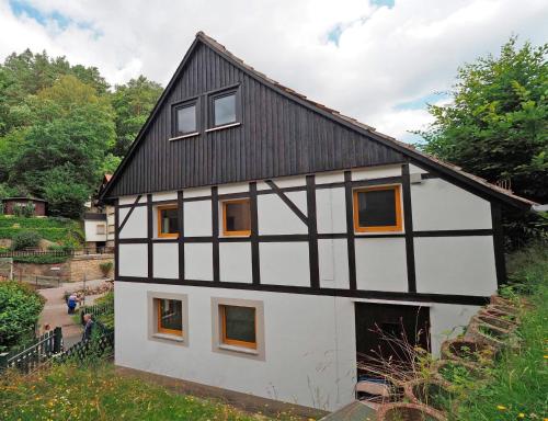 a white and black house with a black roof at Haus Felsental in Rathen