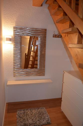 a mirror on the wall of a room with a staircase at Prinz City Apartments mit Klimaanlagen in Neckarsulm