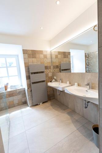 a bathroom with two sinks and a mirror at Hotel-Restaurant-Café Krainer in Langenwang