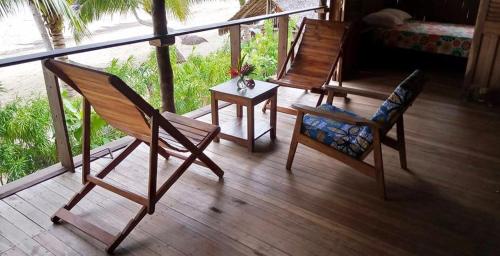 - une terrasse couverte avec 2 chaises et une table sur un balcon dans l'établissement Komba Forever, à Nosy Komba