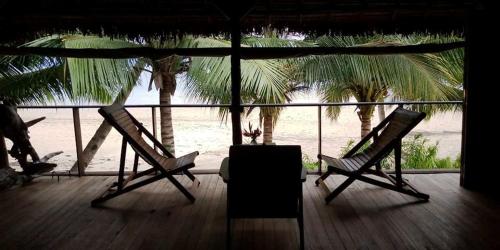- deux chaises sur une terrasse avec vue sur la plage dans l'établissement Komba Forever, à Nosy Komba
