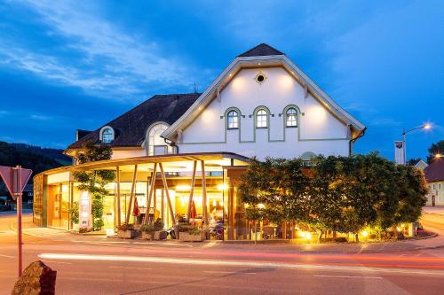 um edifício com muitas janelas numa rua em Hotel-Restaurant-Café Krainer em Langenwang