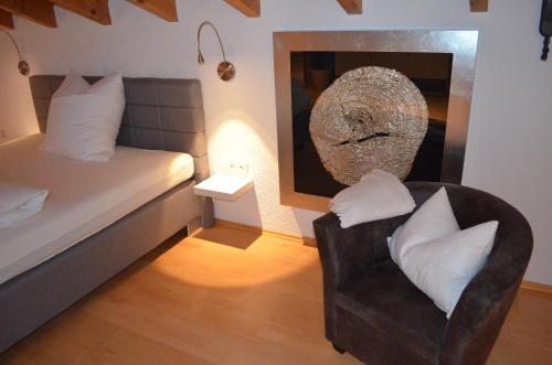 a bedroom with a bed and a chair and a mirror at Prinz City Apartments mit Klimaanlagen in Neckarsulm