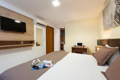 a bedroom with a large bed with a tv on the wall at Pousada Bahia Bacana in Morro de São Paulo