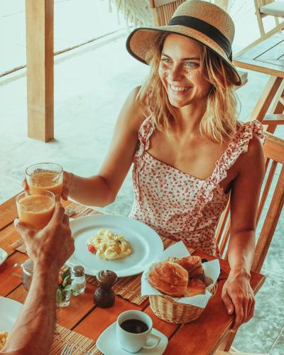 a woman sitting at a table with a plate of food at El Hueco Villas in Lobitos