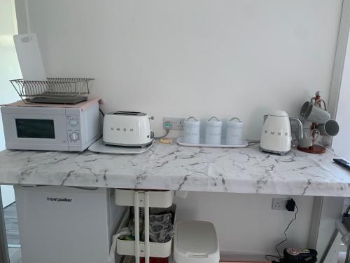 a kitchen counter with a microwave and appliances on it at Nicolas Devon air bed and breakfast in Ilfracombe