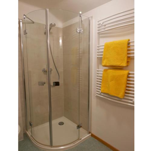 a bathroom with a shower with yellow towels at Sonnhof in Sankt Gilgen