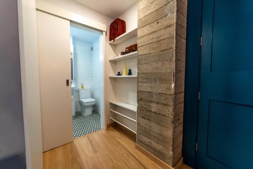 a bathroom with a toilet and a blue door at Eco-Lotf Vegueta in Las Palmas de Gran Canaria