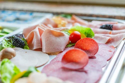 a tray of food with meat and fruits and vegetables at Bergschlößchen in Jüterbog