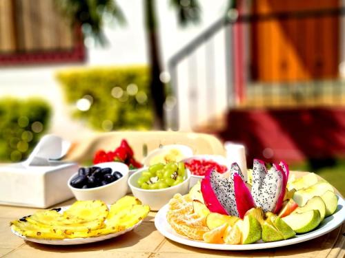 a table with plates of fruit on top of it at Nilgiri Villa with Swimming Pool in Mahabaleshwar