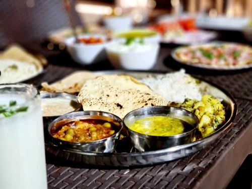 a tray of food with different types of food on a table at Nilgiri Villa with Swimming Pool in Mahabaleshwar