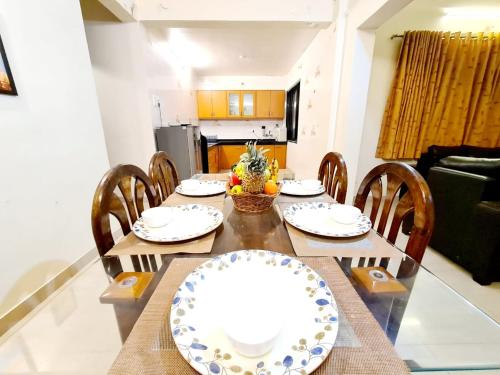 a dining room with a table and chairs and a kitchen at Nilgiri Villa with Swimming Pool in Mahabaleshwar