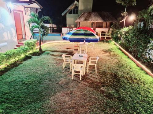a table and chairs with an umbrella in a yard at Nilgiri Villa with Swimming Pool in Mahabaleshwar