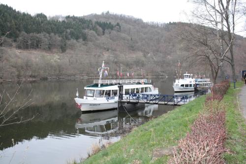 two boats docked at a dock on a river at Am Obersee Hotel in Simmerath