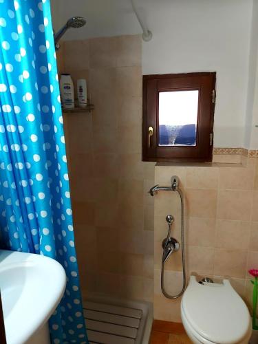 a bathroom with a toilet and a sink and a window at Guest House Piazza Marconi in Amelia