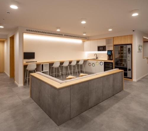 Una cocina grande con encimera con taburetes. en Cristina Enea Rooms, en San Sebastián
