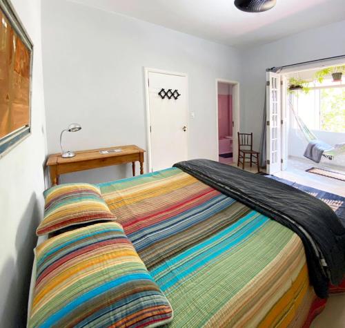 a bed with a colorful blanket on top of it at Suite Paulista x Augusta in Sao Paulo