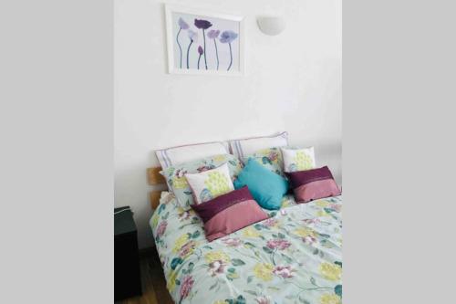 a bedroom with a bed with colorful pillows at Great couples accommodation with beautiful sea view in Lyme Regis