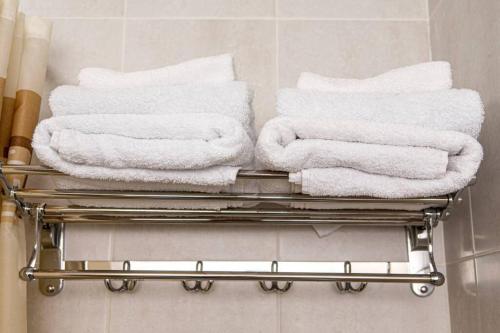 a pile of towels on a towel rack in a bathroom at Уютная студия с видом на горы in Almaty