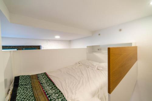 ラスパルマス・デ・グランカナリアにあるEco-Studio Veguetaの白いベッドルーム(木製ヘッドボード付きのベッド1台付)