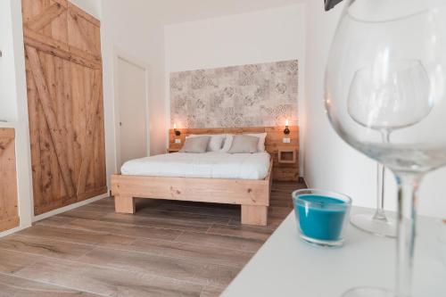 a bedroom with a bed and a wine glass at Le Falesie in Gaeta