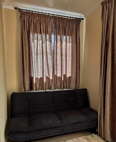 a couch sitting in front of a window at Equi Palace & SPA Near Aeroport in Berrechid