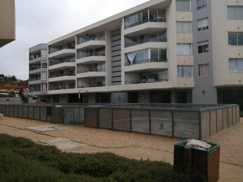 an apartment building with a fence in front of it at vista playa los molles in Los Molles
