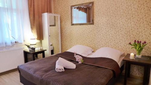 a bedroom with a bed with two towels on it at Wrzos & Belvedere in Kudowa-Zdrój