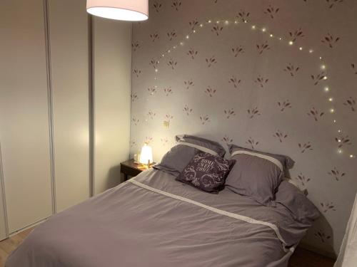 a bedroom with a bed with lights on the wall at Chez Mima in Samadet