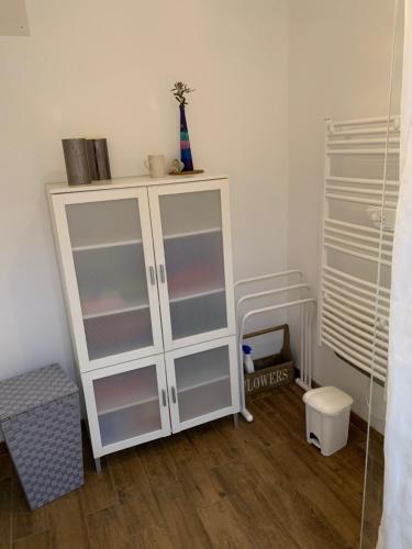 a white cabinet in a room with a wooden floor at Chez Mima in Samadet