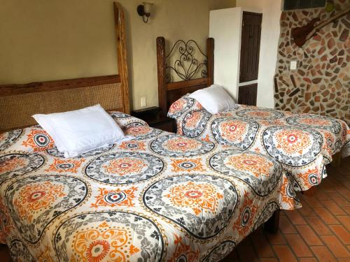 a bedroom with two beds with pillows on it at Casa Miguel Arcangel in Coatepec
