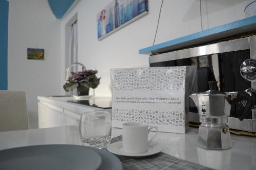 um balcão de cozinha com uma mesa com um prato e uma chávena em Palazzo Persephone em Locri