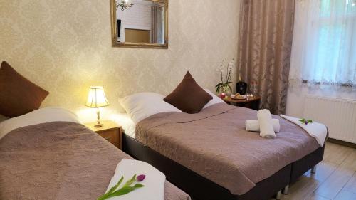 a bedroom with two beds and a mirror at Wrzos & Belvedere in Kudowa-Zdrój