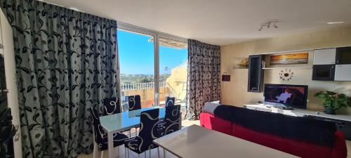 a living room with a table and a window with a view at Il Bejta penthouse in Qala