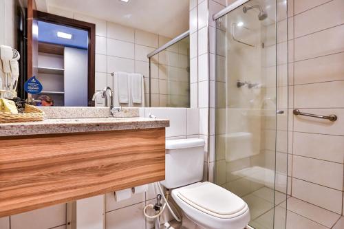 a bathroom with a toilet a sink and a shower at Nobile Suítes Executive in Recife