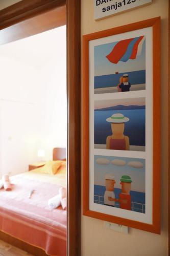 a picture hanging on a wall next to a bed at Apartments Suzana in Ždrelac