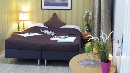 a bedroom with a bed with towels and a table at Wrzos & Belvedere in Kudowa-Zdrój