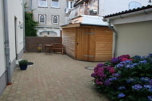 a courtyard with a wooden fence and flowers at Stadtwohnung 8 in Wyk auf Föhr